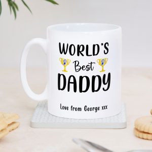 Personalised ceramic mug with bold text “World’s Best Daddy” and trophy icons, customised with customisable child’s name message at the bottom. White 11oz coffee or tea cup, dishwasher safe, perfect Father’s Day gift, birthday present, or sentimental keepsake for dad, stepdad, or father figure from son or daughter. High quality UK handmade daddy gift idea.