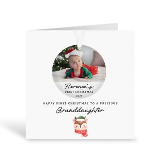 Personalised granddaughter first Christmas card and acrylic tree bauble featuring custom baby photo, festive reindeer illustration, luxury square greeting card with removeable ornament keepsake, holiday gift for granddaughter’s first Christmas, unique custom Christmas decoration with ribbon, sentimental family gift idea