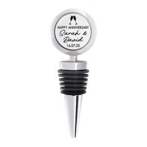 A personalised silver metal bottle stopper featuring a printed Happy Anniversary design with the couple’s names and date, set against a white background. Perfect custom wine gift for couples celebrating their anniversary, handmade in the UK by Drifting Ducks, includes presentation box and organza gift bag.