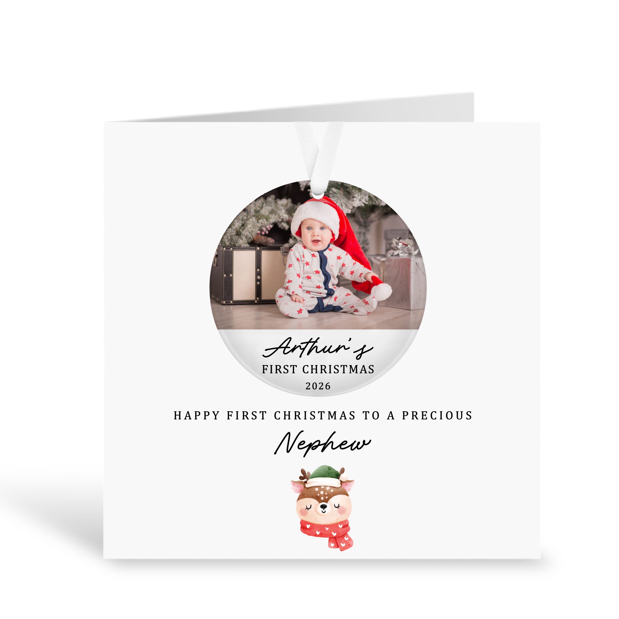 Personalised first Christmas nephew card featuring a removable acrylic bauble decoration with a baby photo wearing a Santa hat. Custom card reads “Arthur’s First Christmas 2026” and “Happy First Christmas to a Precious Nephew”. Handmade luxury 300gsm greeting card with a cute festive reindeer design and white ribbon for hanging the bauble. Perfect keepsake Christmas gift for a baby nephew.
